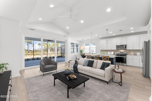 living area featuring lofted ceiling, recessed lighting, a ceiling fan, and light wood-type flooring