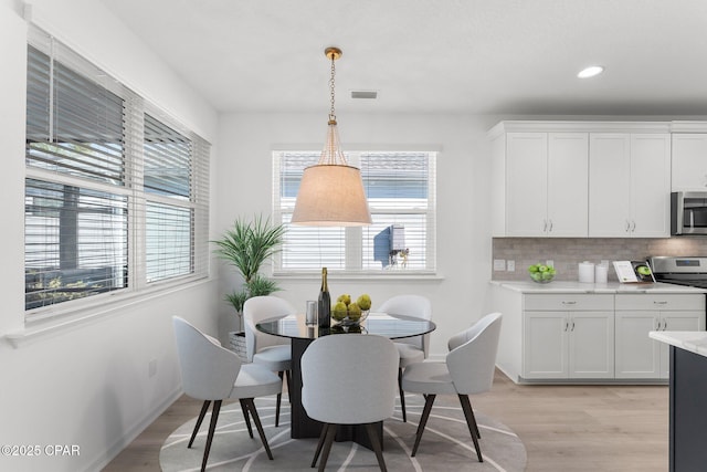 dining room featuring recessed lighting, baseboards, visible vents, and light wood-type flooring