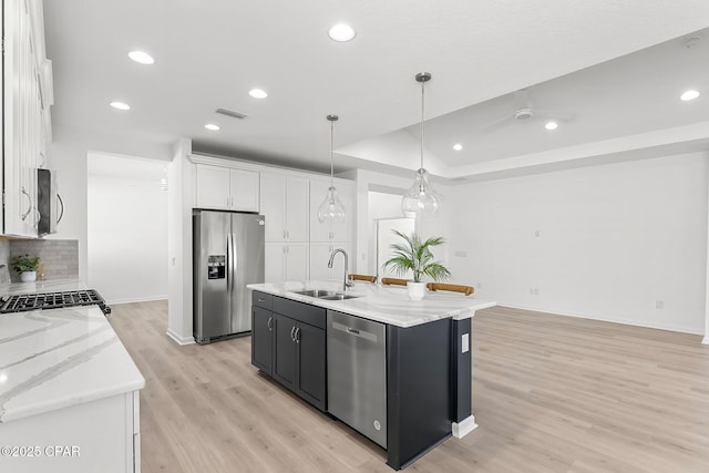 kitchen with visible vents, a sink, appliances with stainless steel finishes, white cabinetry, and light wood-type flooring