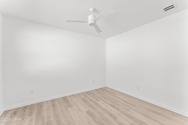 spare room with light wood-style flooring, baseboards, visible vents, and ceiling fan