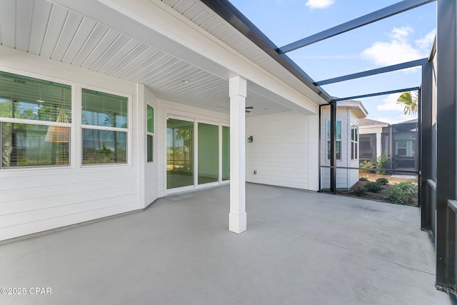 view of patio / terrace featuring a carport and glass enclosure