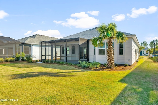 rear view of property with a lawn and roof with shingles