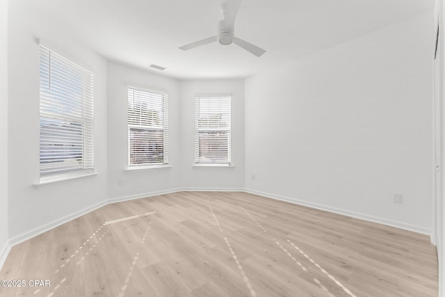 spare room with visible vents, baseboards, light wood-type flooring, and a ceiling fan