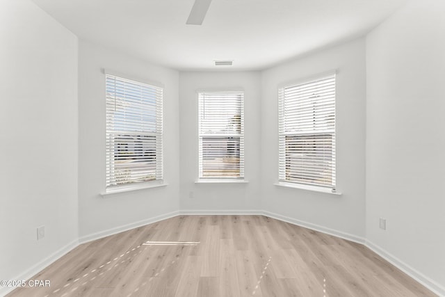 unfurnished room with ceiling fan, baseboards, and light wood-style flooring