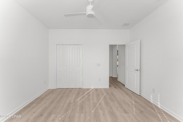 unfurnished bedroom featuring light wood-style floors, a closet, and baseboards