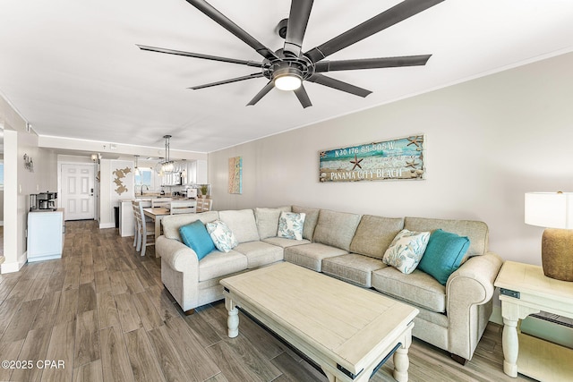 living room featuring ornamental molding, a ceiling fan, and wood finished floors