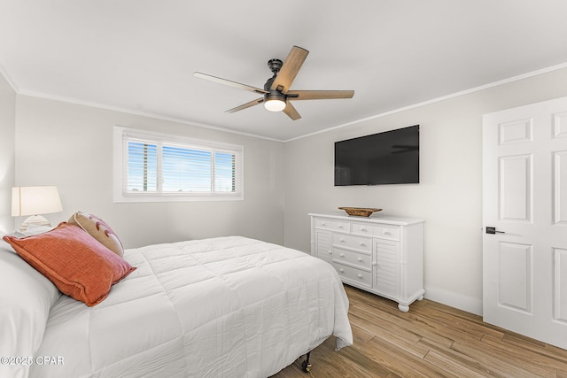 bedroom with a ceiling fan, crown molding, and light wood-style flooring