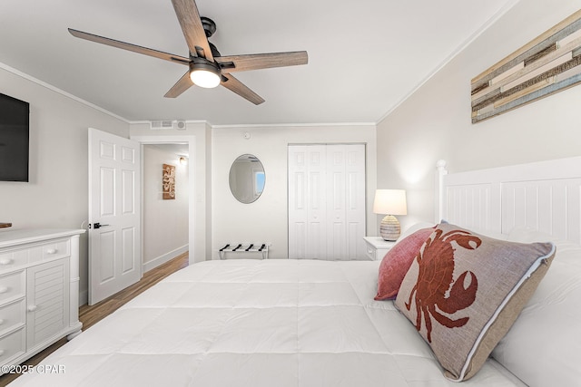 bedroom with ceiling fan, ornamental molding, a closet, and visible vents