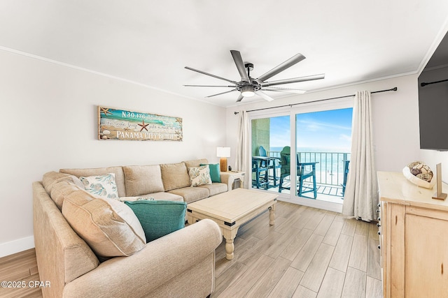 living room with light wood-style floors, ornamental molding, baseboards, and ceiling fan