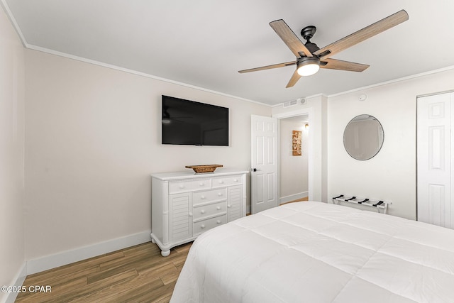 bedroom with crown molding, visible vents, light wood-style flooring, ceiling fan, and baseboards