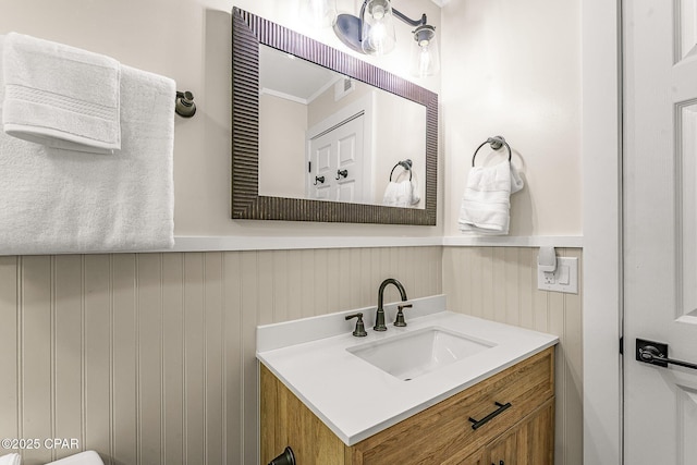 bathroom with a wainscoted wall and vanity