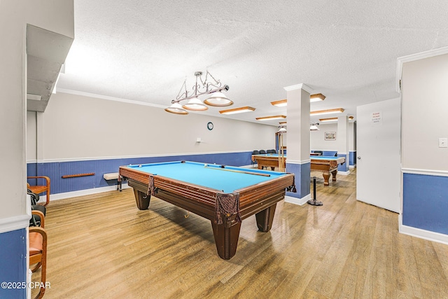 recreation room featuring a wainscoted wall, pool table, a textured ceiling, and wood finished floors