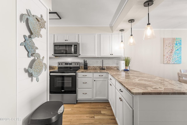 kitchen featuring a peninsula, light wood-style flooring, ornamental molding, and stainless steel appliances