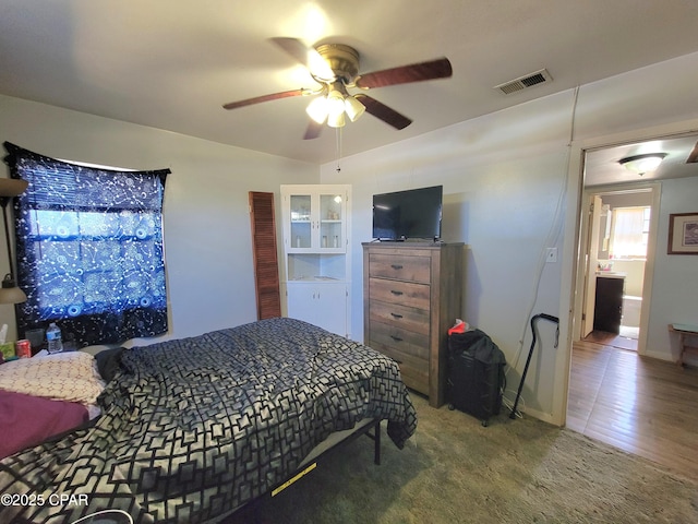 carpeted bedroom with ceiling fan and visible vents