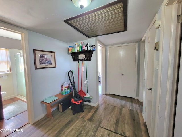 corridor featuring baseboards and wood finished floors