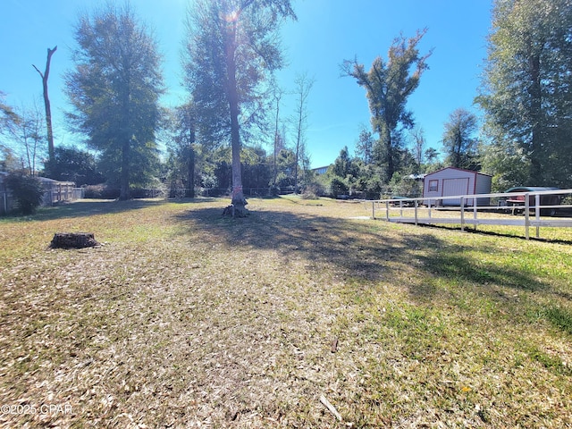 view of yard with a storage unit, an outdoor structure, and fence