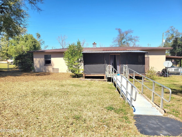 exterior space featuring fence, a front lawn, and stucco siding