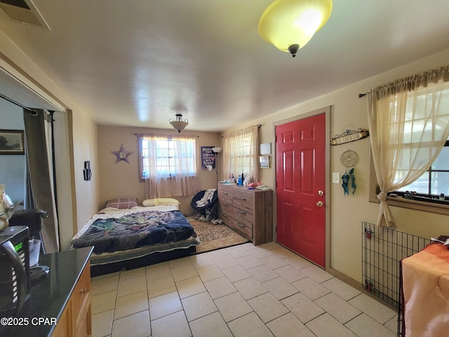 bedroom with light tile patterned floors and visible vents