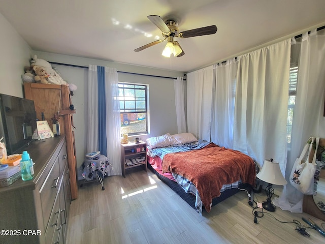 bedroom with ceiling fan and light wood-style floors