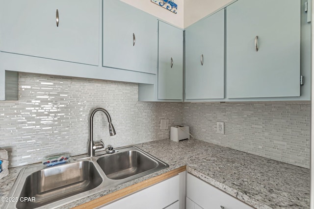 kitchen featuring light countertops, a sink, and decorative backsplash