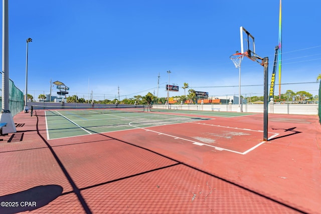 view of basketball court featuring a tennis court, community basketball court, and fence