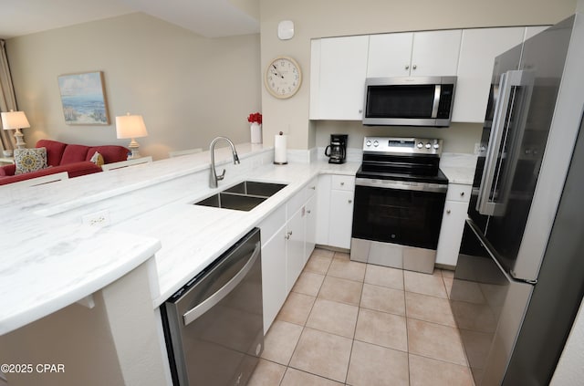 kitchen featuring stainless steel appliances, white cabinets, a sink, and light tile patterned floors