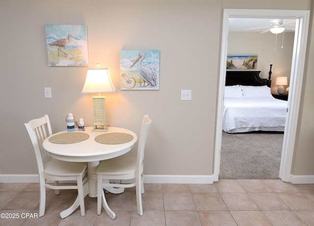 dining space featuring light tile patterned floors, light colored carpet, and baseboards