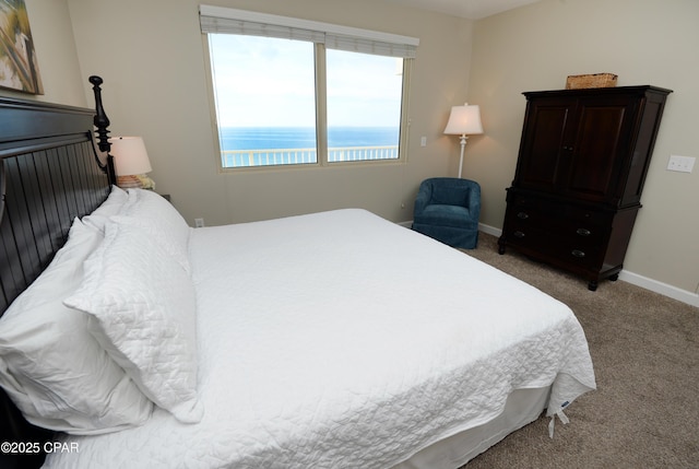 carpeted bedroom featuring a water view and baseboards