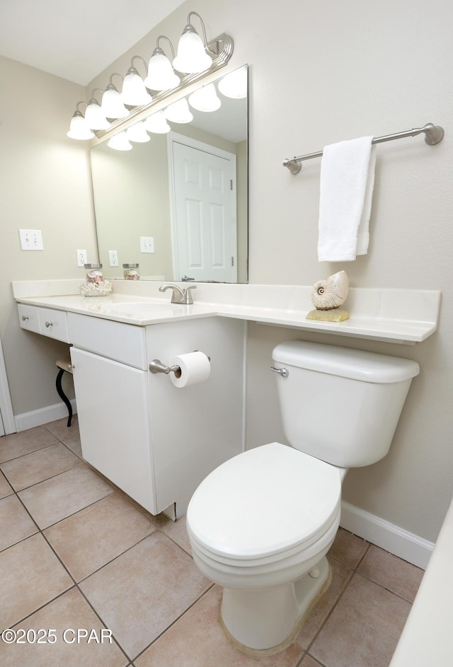 half bathroom with vanity, tile patterned flooring, toilet, and baseboards