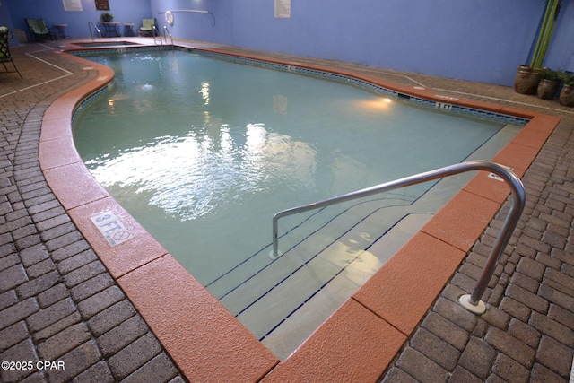 community pool featuring a community hot tub and a patio