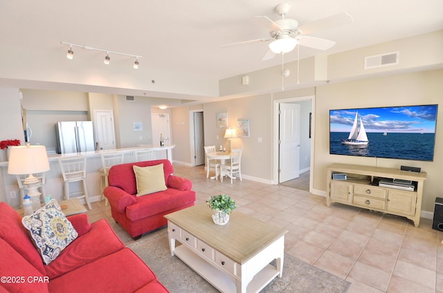 living room featuring light tile patterned floors, ceiling fan, visible vents, and baseboards