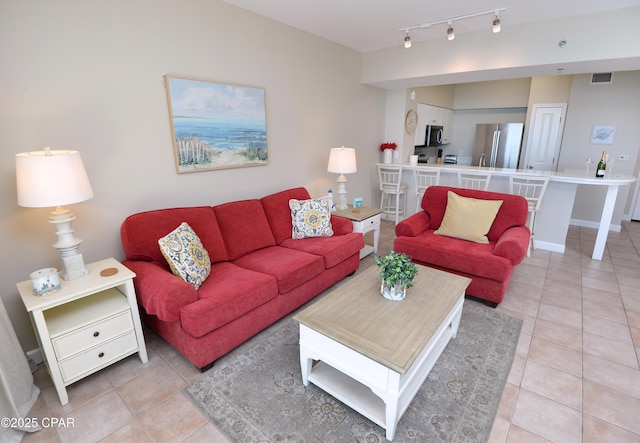 living room featuring light tile patterned floors, visible vents, and track lighting