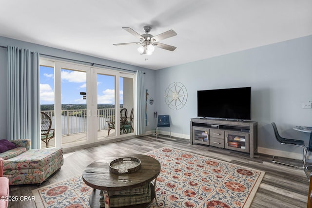 living area featuring ceiling fan, wood finished floors, and baseboards