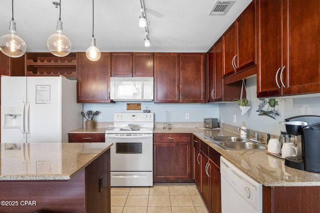 kitchen featuring white appliances, visible vents, hanging light fixtures, dark brown cabinets, and a sink