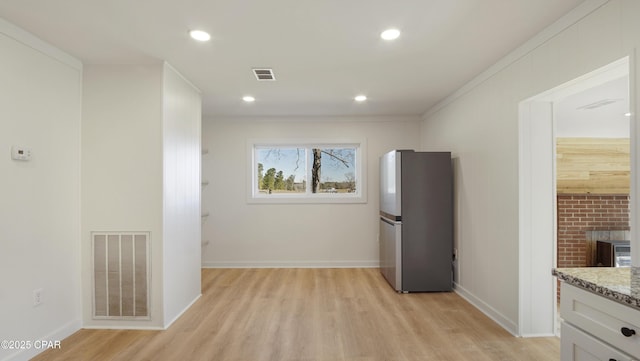 kitchen with freestanding refrigerator, visible vents, light wood finished floors, and recessed lighting