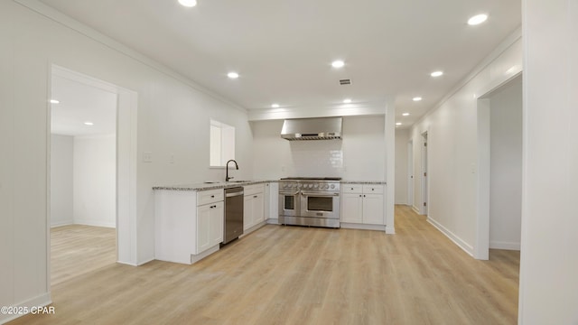 kitchen with stainless steel appliances, visible vents, white cabinets, wall chimney range hood, and light wood-type flooring