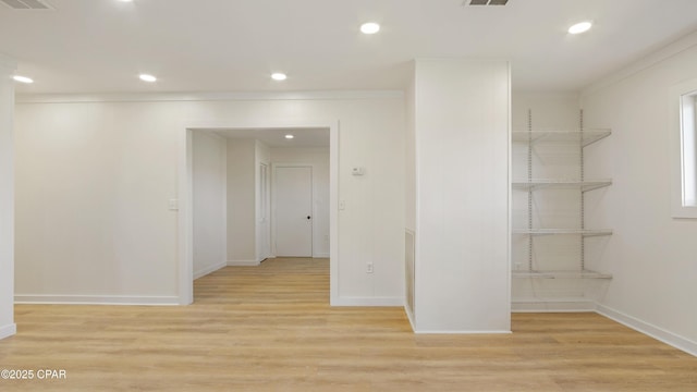 spare room with light wood-style floors, baseboards, and visible vents