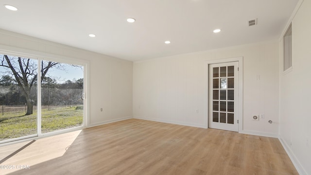 empty room featuring light wood-type flooring, visible vents, crown molding, and recessed lighting