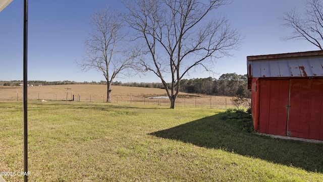 view of yard with a storage shed, a rural view, and an outdoor structure