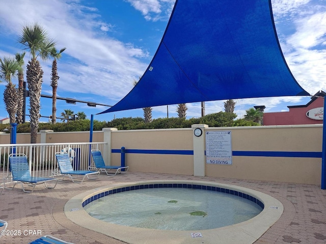 view of pool with fence and a hot tub