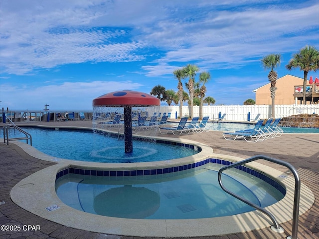 community pool with a hot tub and fence