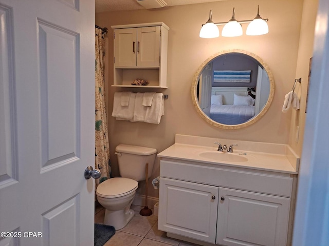 bathroom with toilet, vanity, and tile patterned flooring