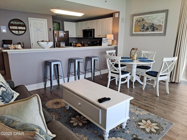 living area with wood finished floors and baseboards