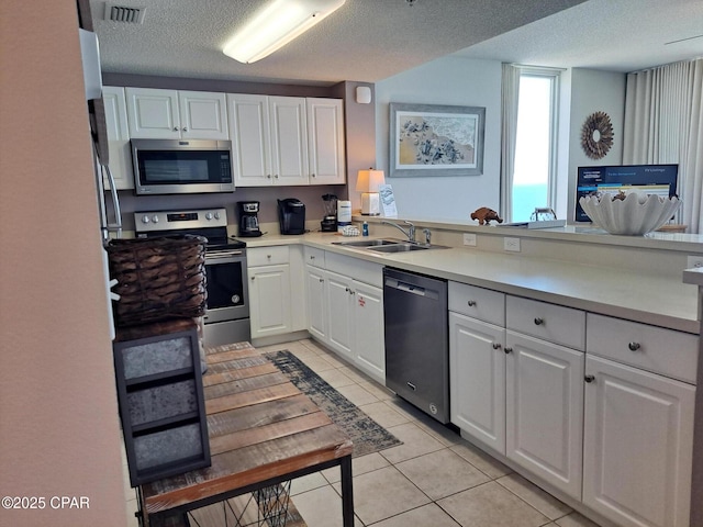 kitchen featuring white cabinets, visible vents, appliances with stainless steel finishes, and a sink