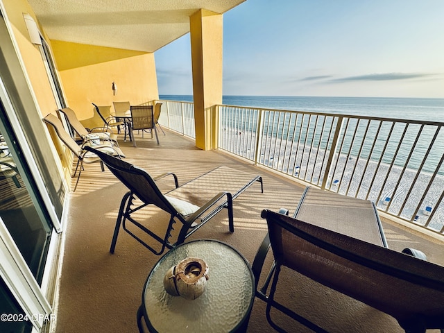 balcony with a water view and a beach view