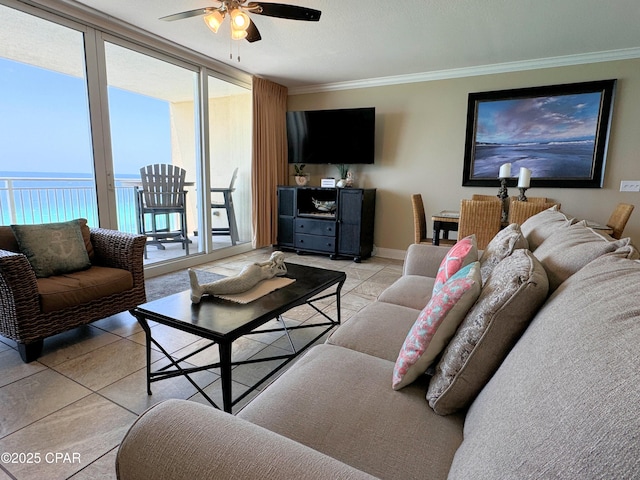 living room with a ceiling fan, crown molding, baseboards, and light tile patterned floors