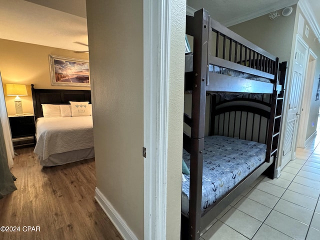 tiled bedroom with baseboards and crown molding