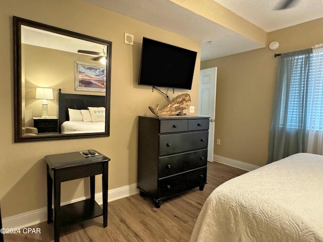 bedroom with wood finished floors and baseboards