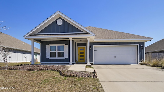 view of front of home featuring board and batten siding, concrete driveway, a garage, and a shingled roof