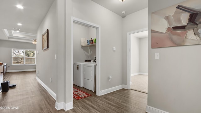 hallway featuring baseboards, independent washer and dryer, and wood finished floors
